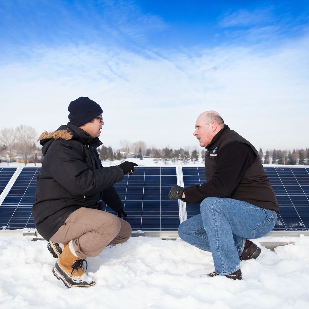 Two men talk about Community Solar Gardens in the snow. © NAIT 2016, made available under a Creative Commons 2.0 license.