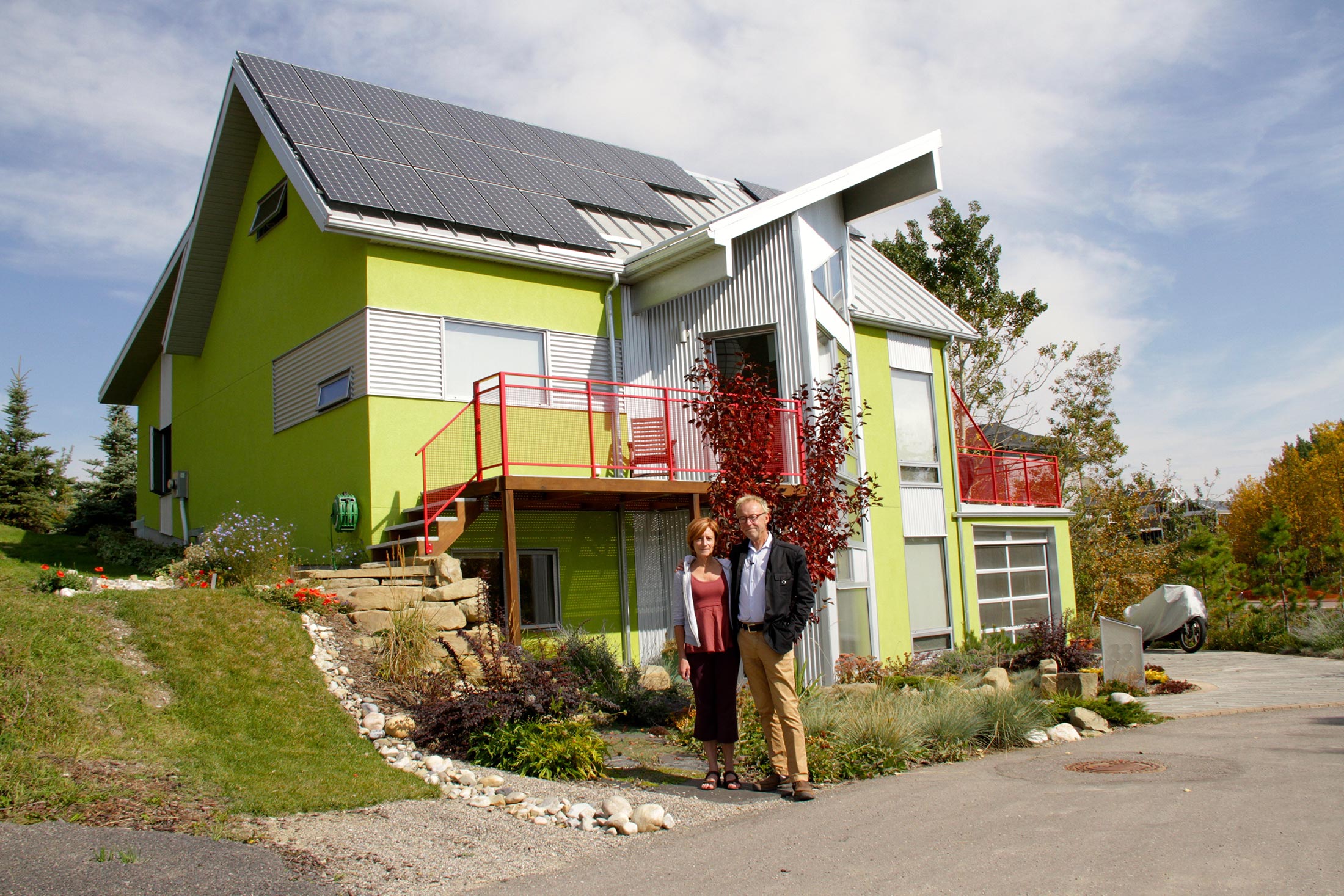 Homeowners stand in front of their solar powered home. © David Dodge, made available under a Creative Commons 2.0 license.